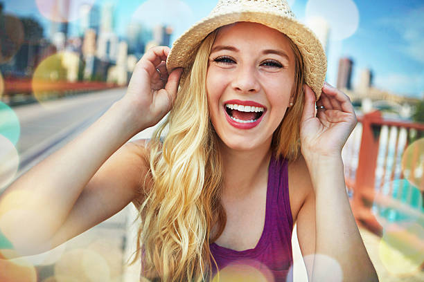 Shot of a smiling young woman walking around the city in the summertime