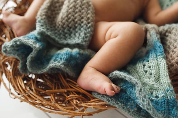 piernas del bebé acostado en primer plano de la cuna de mimbre - baby animal nest newborn lying down fotografías e imágenes de stock