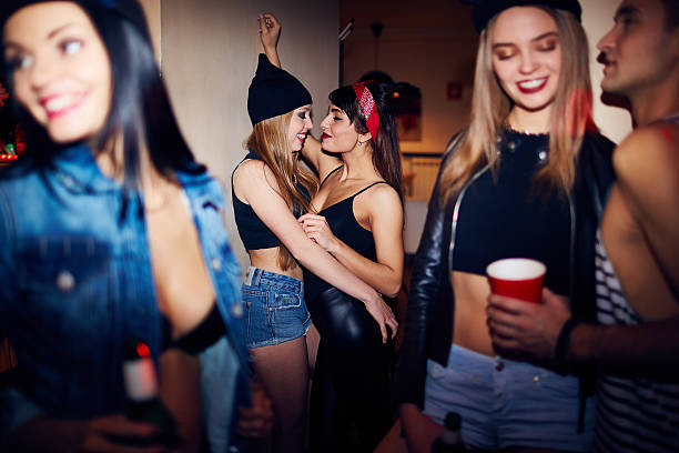 Drunk Girls Dancing at Party Two drunk student girls dancing close together, in dark corner of nightclub at noisy party vex nightclub stock pictures, royalty-free photos & images