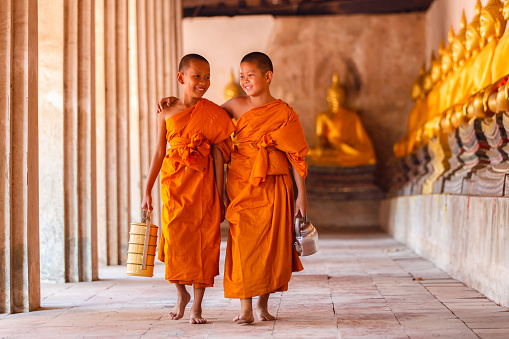 Dos novicios caminando y hablando en el antiguo templo photo