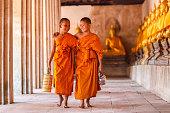 Two novices walking and talking in old temple