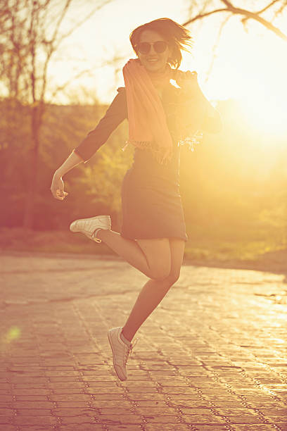 istock Girl jumping on a sunset background 623184432