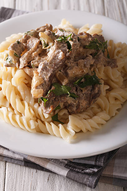 istock beef stroganoff with pasta close-up on a plate. Vertical 623184892