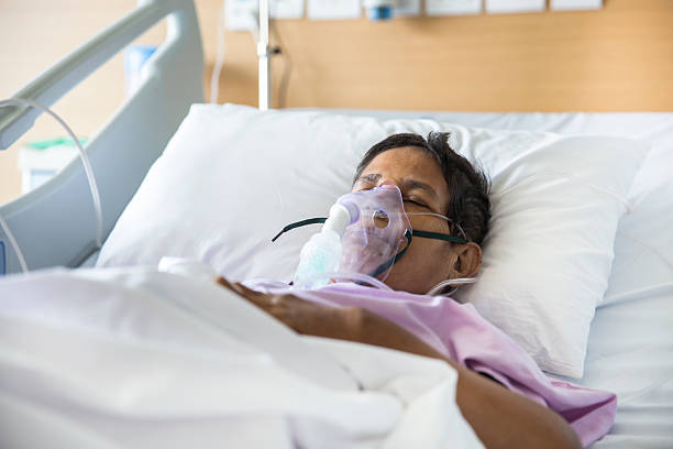 Old woman with Ventilator mask on Hospital bed Old woman patient lying on Hospital bed with ventilator mask on her nose. She has her eyes closed. medical ventilator photos stock pictures, royalty-free photos & images