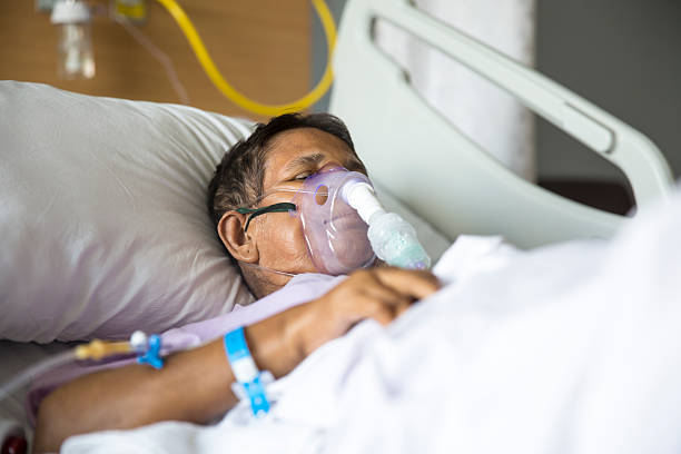 Old woman with Ventilator mask on Hospital bed Old woman patient lying on Hospital bed with ventilator mask on her nose. She has her eyes closed. medical oxygen stock pictures, royalty-free photos & images