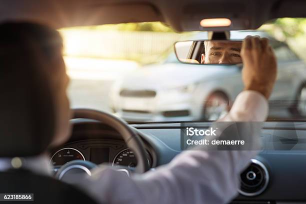 Man Adjusting A Rearview Mirror Stock Photo - Download Image Now - Car, Rear-View Mirror, Looking