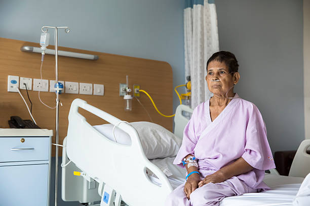 Old woman patient sitting on a Hospital bed stock photo