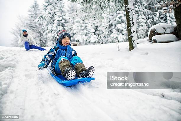 Mother And Son Playing In Snow Stock Photo - Download Image Now - Child, Winter, Sledding