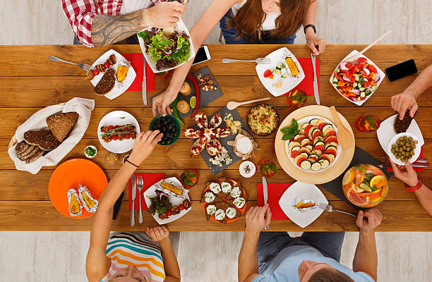 istock People eat healthy meals at festive table dinner party 623197268