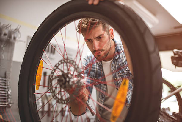 istock Mechanic repairing bicycle wheel 623198060
