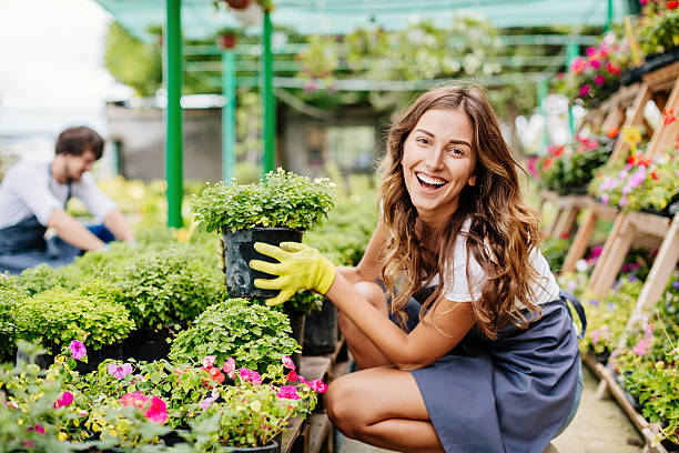 garota sorridente no centro do jardim - garden center flower women plant - fotografias e filmes do acervo