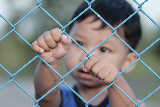 istock The boy standing of  pulling a metal fence . 623200468