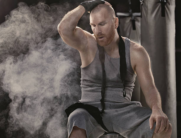 istock Caucasian shaved male adult boxer sitting alone exhausted after workout 623202128