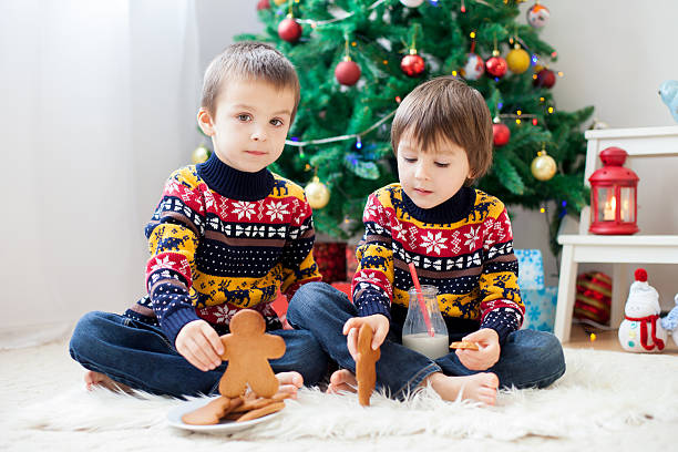 istock Two adorable children, boy brothers, eating cookies and drinking 623203866