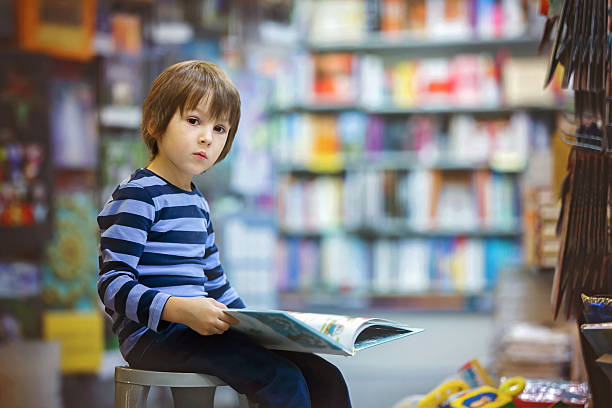 istock Adorable little child, boy, sitting in a book store 623204764