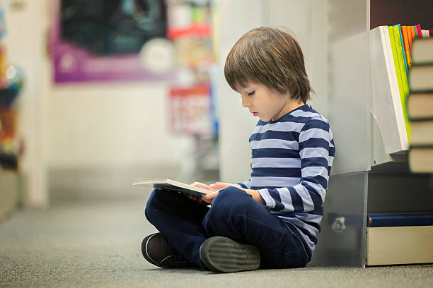 istock Adorable little child, boy, sitting in a book store 623204816