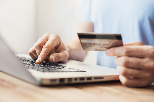 Young man shopping with credit card and laptop computer