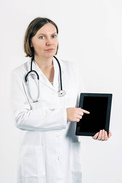 istock Female doctor finger pointing to blank tablet computer screen di 623206066