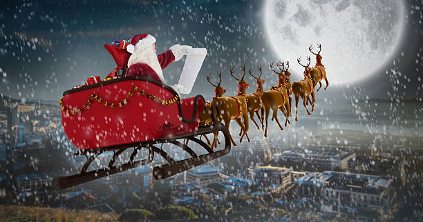 istock Santa Claus riding on sled during Christmas against city 623209064