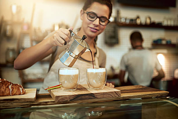 Shot of a young woman preparing fresh coffee in a cafe