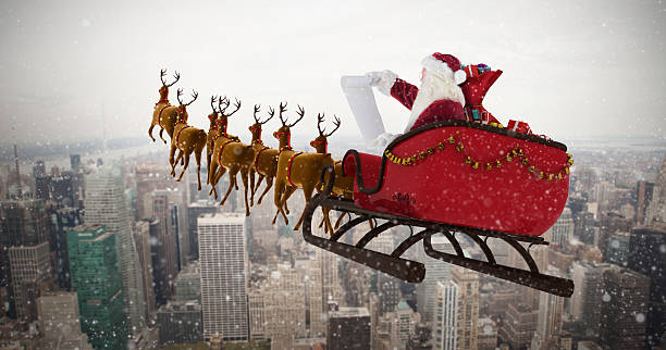 weihnachtsmann fährt zu weihnachten auf schlitten gegen skyline der stadt - caucasian three dimensional shape men sky stock-fotos und bilder
