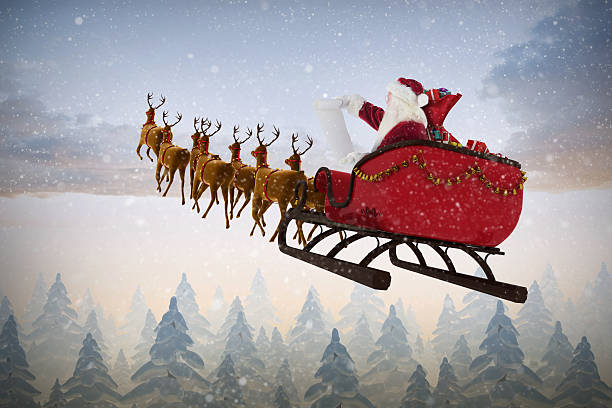 istock Santa Claus riding on sled during Christmas against snow falling 623209308