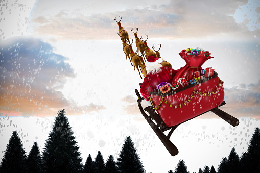 High angle view of Santa Claus riding on sled during Christmas against snow falling on fir tree forest