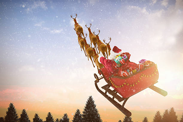 istock anta Claus riding on sled with against snow falling 623209382