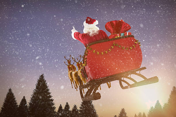 istock Santa Claus riding on sled with gift box against sunset 623209434