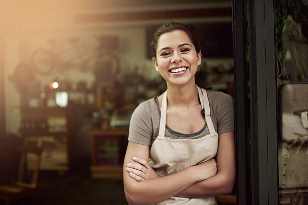 Pop in to your local coffee parlor Portrait of a confident young woman standing in the doorway of a coffee shop barista stock pictures, royalty-free photos & images