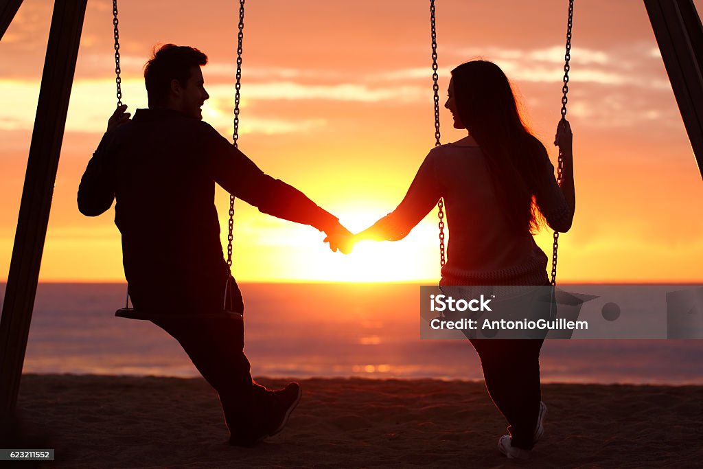 Coppia silhouette tenersi per mano guardando un'alba - Foto stock royalty-free di Relazione di coppia