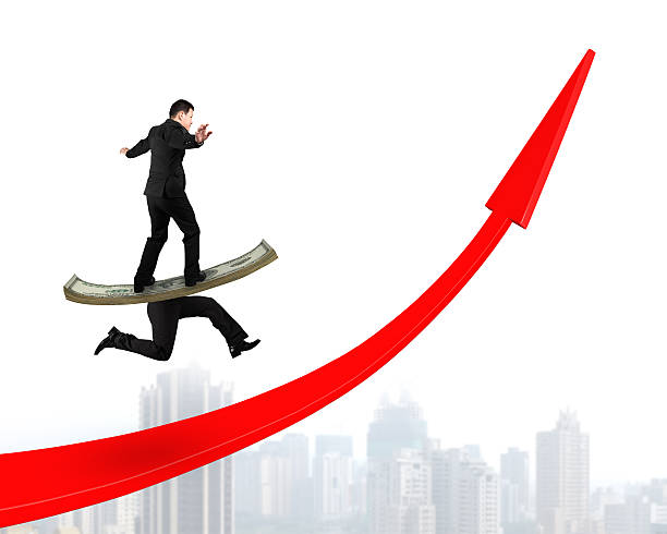 istock Man balancing running money legs on red arrow up 623212754