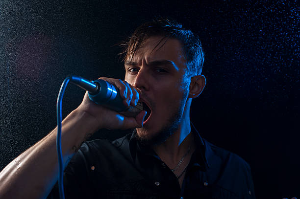 istock Portrait of attractive man singing into microphone 623213538