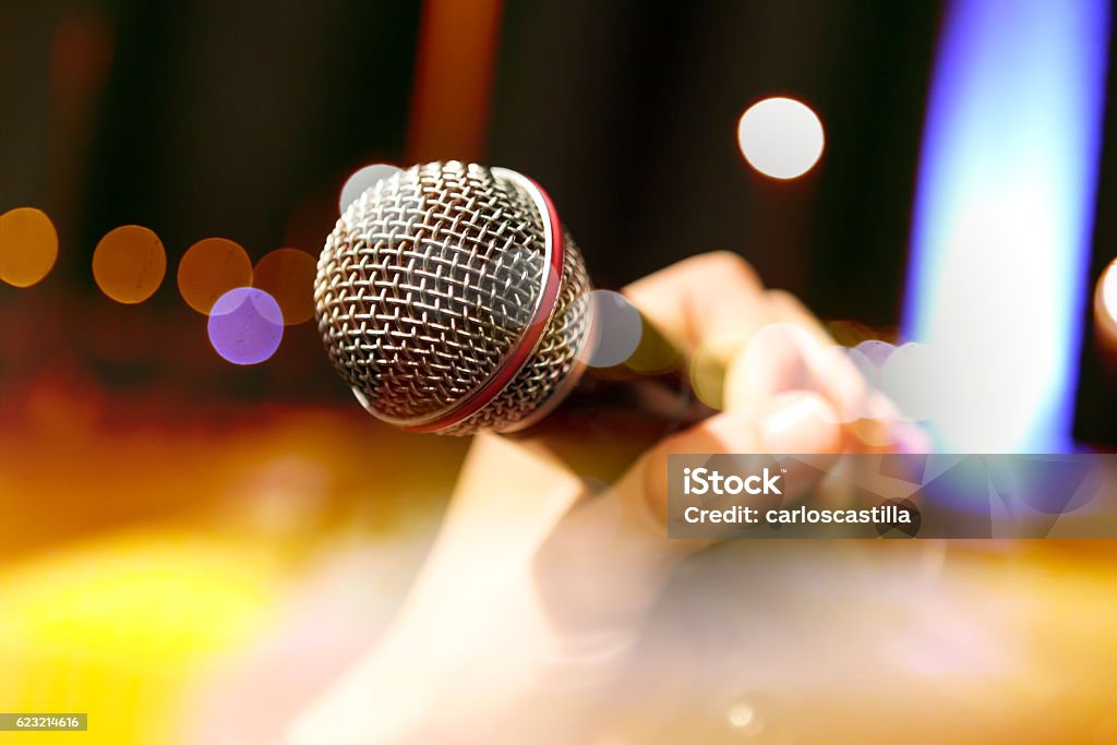 Musical background.Mic and singer Live music background.Karaoke and microphone concept.Stage lights and singer Microphone Stock Photo