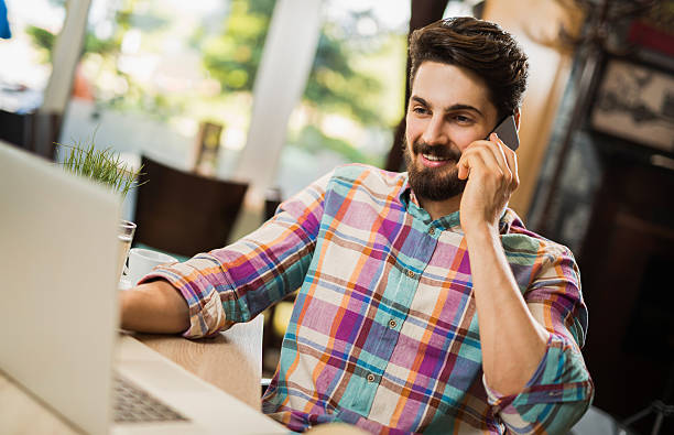 istock Young cheerful businessman talking on mobile phone in cafe. 623214848