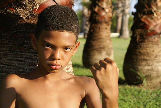 A boy threatening with his fist. Vertical Shot.