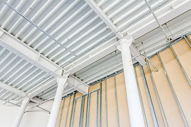 Low angle view on structure girders with metal skeleton at indoor ceiling construction.