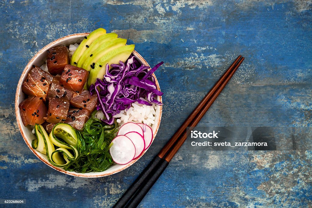 Hawaiian tuna poke bowl with seaweed, avocado, red cabbage slaw Hawaiian tuna poke bowl with seaweed, avocado, red cabbage slaw, radishes and black sesame seeds. Top view, overhead, flat lay, copy space Poke - Food Stock Photo