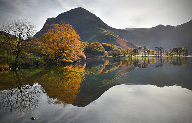 Cumbrian autumn reflections Misty autumn reflection and colours at Buttermere Lake english lake district stock pictures, royalty-free photos & images