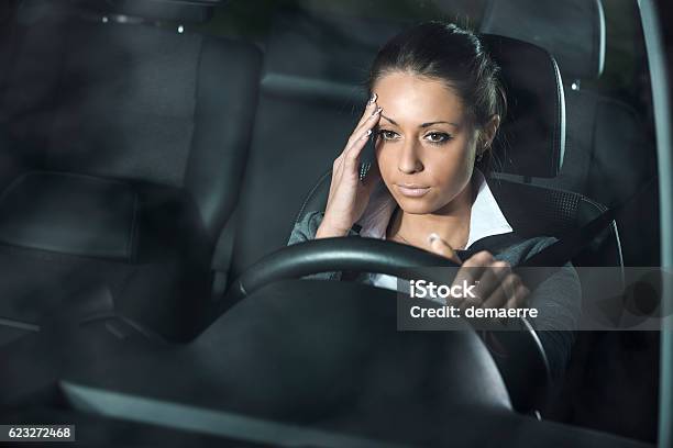 Mujer Con Dolor De Cabeza Conduciendo Foto de stock y más banco de imágenes de Cansado - Cansado, Conducir, Noche