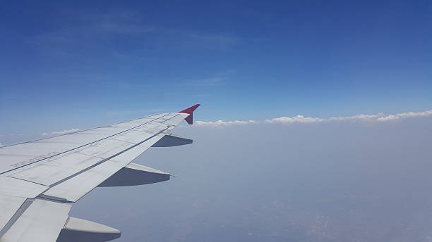 istock Airplane wing out of window and sky. 623273290