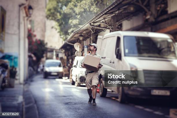 Messenger Delivering Parcel Walking In Street Next To His Van Stock Photo - Download Image Now