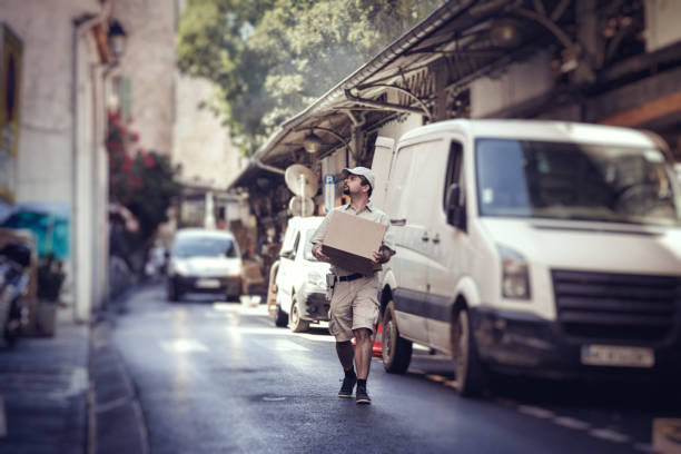 messenger entrega parcela, andar na rua ao lado de sua van - postal worker truck driver delivering delivery person imagens e fotografias de stock