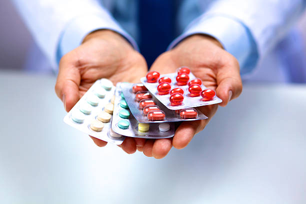 istock young doctor holds the patient's hand with pills 623279710