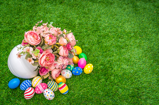 Artificial flowers on grass with Easter eggs