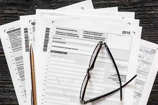 istock German tax form with pen and glasses on a table. 623280664