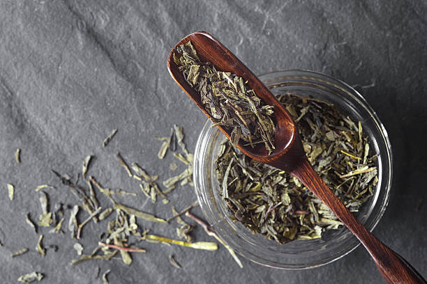 istock Glass jar with tea and wooden spoon on stone background 623281756