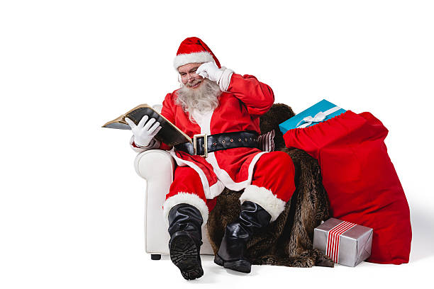 istock Santa reading bible with sack of christmas present 623286612