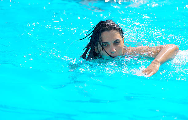 istock Beautiful young woman swimming in pool 623289192