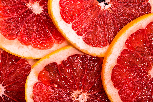 istock Sliced grapefruits, background, natural texture of citrus, top view, close-up 623289430